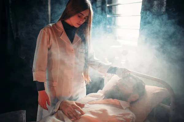 Hastanede hasta adama karşı duran kadın — Stok fotoğraf