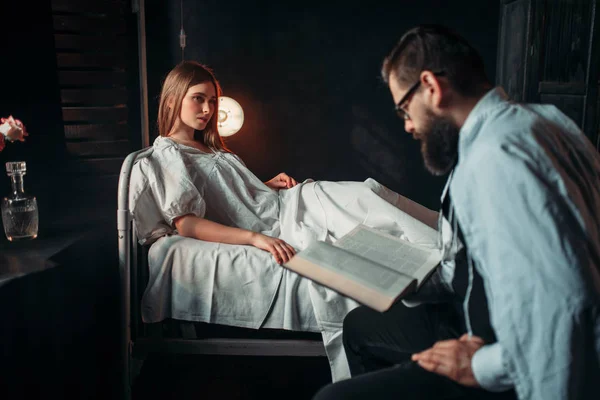 Man lezen boek tegen de zieke vrouw — Stockfoto