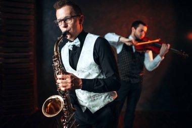 male musicians playing saxophone and violin clipart