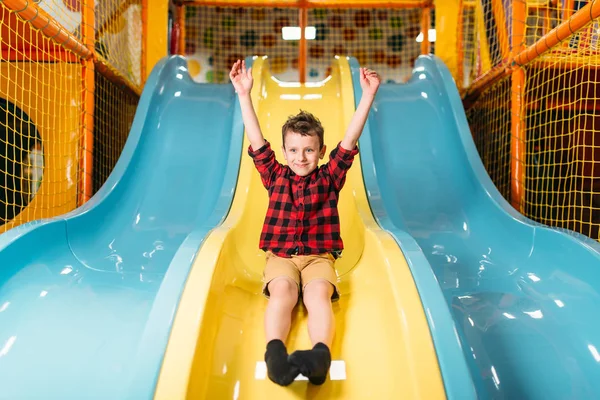 Pequeno menino deslizando no playground — Fotografia de Stock