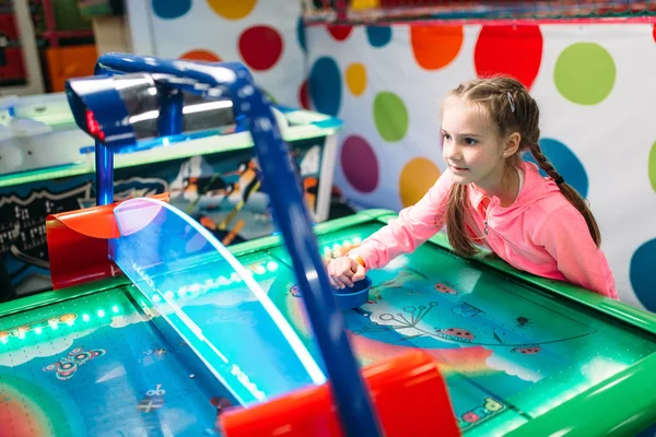 Liten flicka spela airhockey — Stockfoto