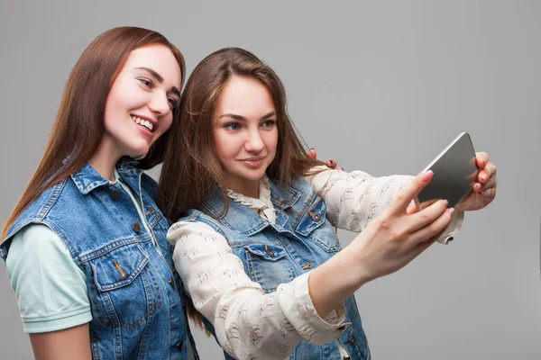 Two attractive girlfriends making selfie Stock Image