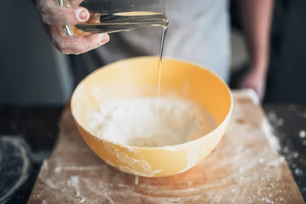 Пекарь добавляет ингредиенты в миску — стоковое фото