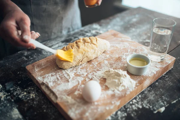 Baker manchando manteiga na massa — Fotografia de Stock
