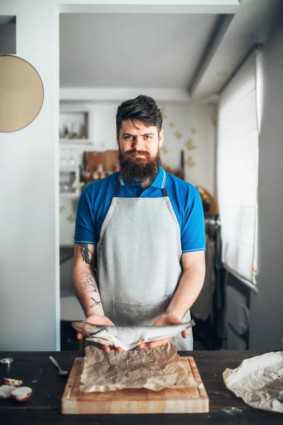 Чоловічий шеф-кухар, що тримає сиру рибу — стокове фото