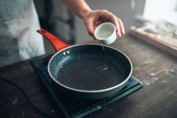 Chef versando olio alla padella — Foto Stock