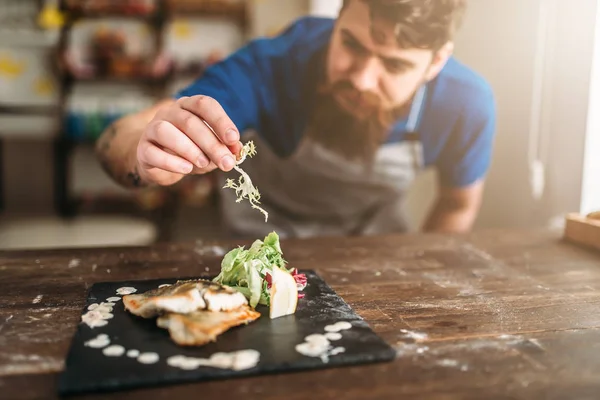 Chef decorating dish of fried fish — Stock Photo, Image