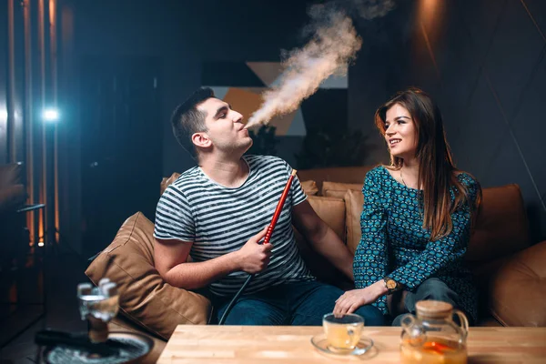Joven pareja fumando narguile — Foto de Stock