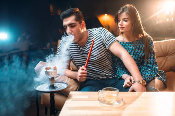 Молода пара курить кальян — стокове фото