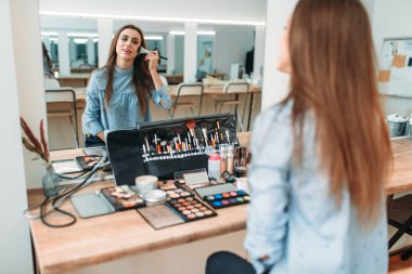 Kadın fırçayla makyaj yapıyor