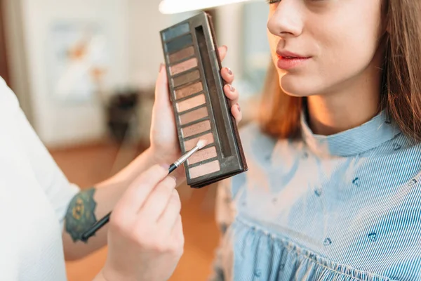 Make up artist holding eyesshadow palette — стоковое фото