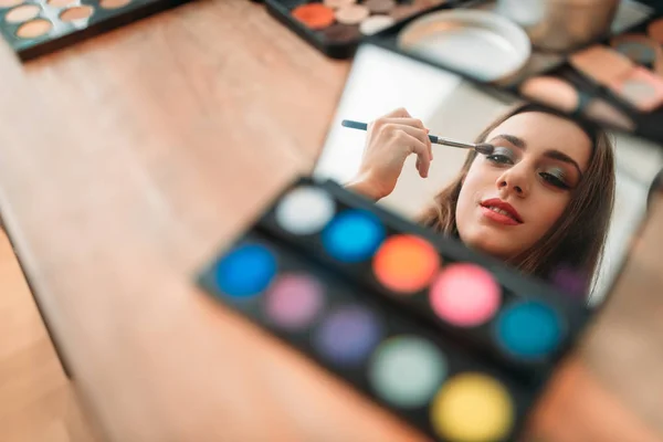 Žena aplikující make-up štětcem — Stock fotografie