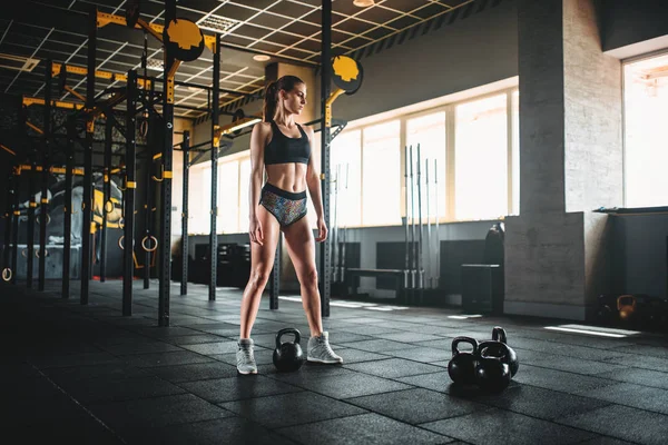 Athlète féminine posant dans la salle de gym — Photo