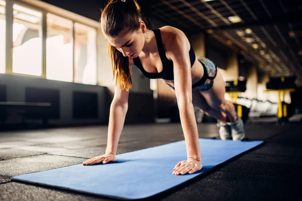 Atleta femenina haciendo ejercicios push-up — Foto de Stock