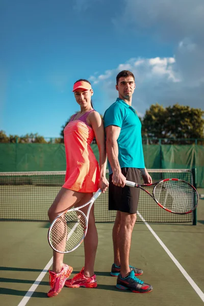 Couple attrayant avec raquettes de tennis — Photo