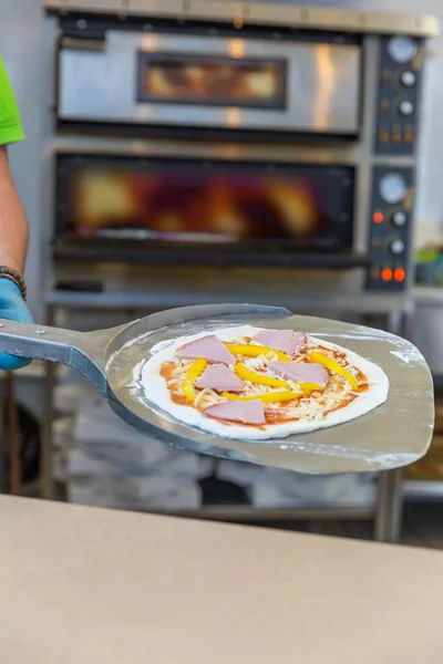 Att sätta raw pizza i ugn — Stockfoto