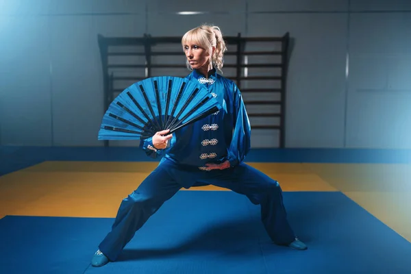 Ženské wushu bojovník školení s ventilátorem — Stock fotografie