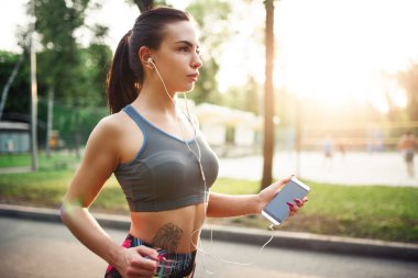 Kadın parkta koşuyor.