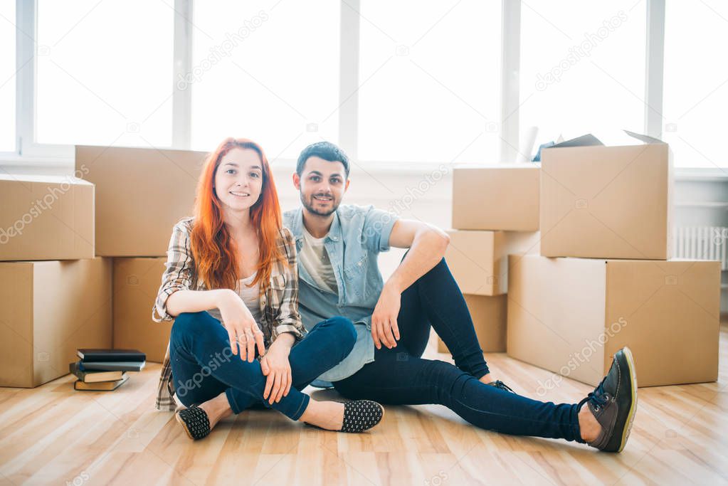 couple with cardboard boxes in new apartment