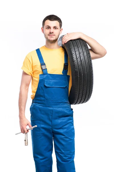 Opravář modrou uniformu s pneu — Stock fotografie
