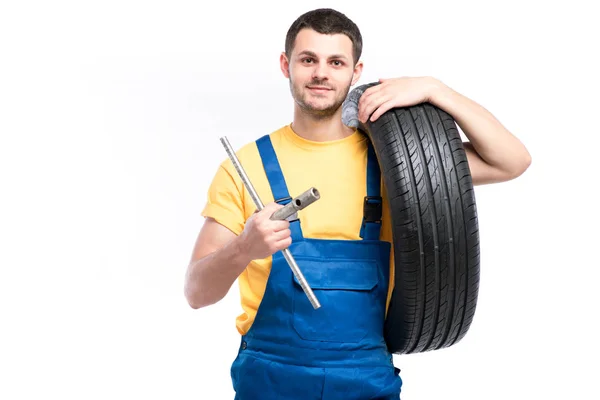 Repairman in blue uniform with tire — Stock Photo, Image