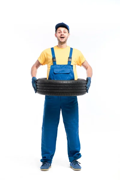 Repairman in blue uniform with tire — Stock Photo, Image