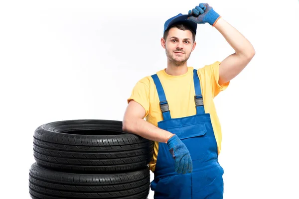 Reparador em uniforme azul com pneus — Fotografia de Stock