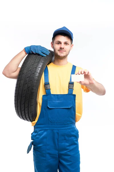 Reparador en uniforme azul con neumático — Foto de Stock