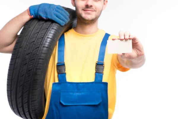 Reparador en uniforme azul con neumático —  Fotos de Stock