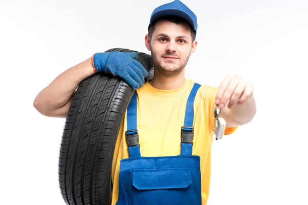 Reparador en uniforme azul con neumático —  Fotos de Stock