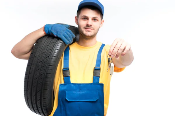 Reparador em uniforme azul com pneu — Fotografia de Stock