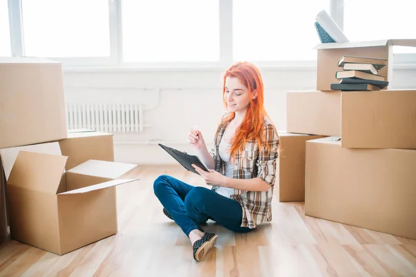 Mujer sentada cerca de cajas en nuevo apartamento — Foto de Stock