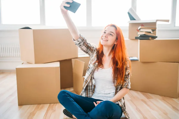 Woman sitting near boxes in new apartment — Stock Photo, Image