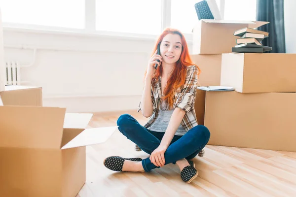 Mujer sentada cerca de cajas en nuevo apartamento — Foto de Stock