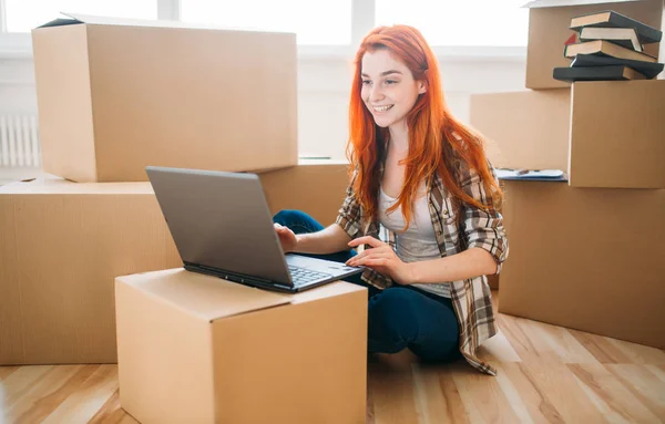 Woman sitting near boxes in new apartment — Stock Photo, Image