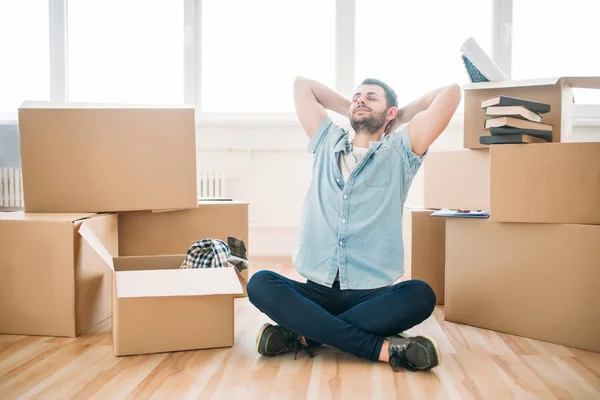 Hombre sentado cerca de cajas de cartón — Foto de Stock