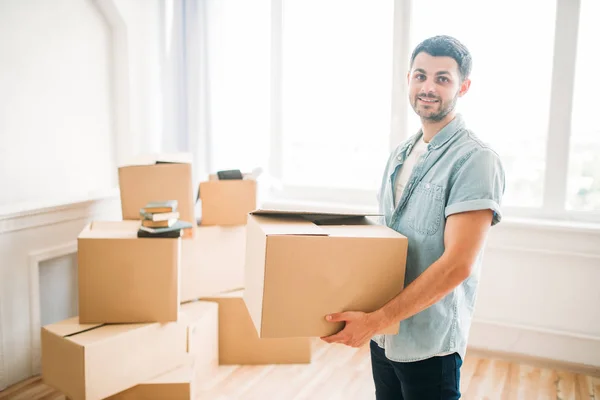 Hombre sentado sosteniendo caja de cartón — Foto de Stock