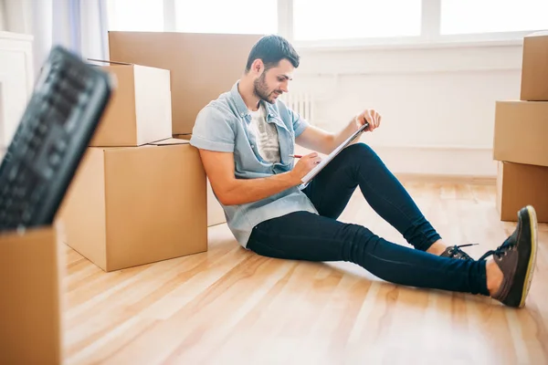 Hombre sentado cerca de cajas de cartón — Foto de Stock