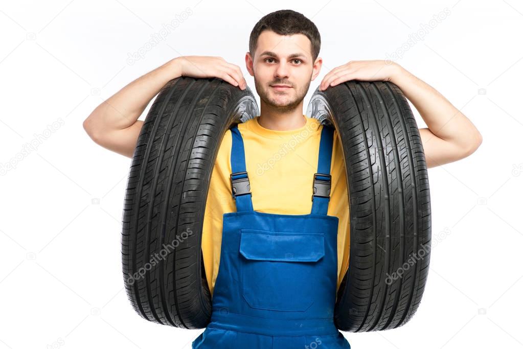 repairman in blue uniform with tires