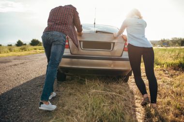 man and woman pushing broken car clipart