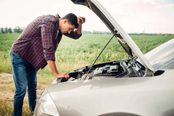 Mann versucht kaputtes Auto zu reparieren — Stockfoto