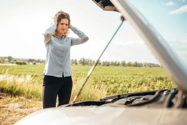 Kvinnan försöker reparera trasiga bil — Stockfoto