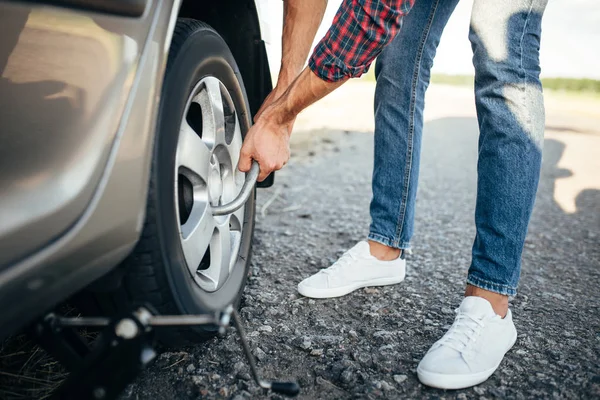 Homem tentando substituir roda de carro — Fotografia de Stock