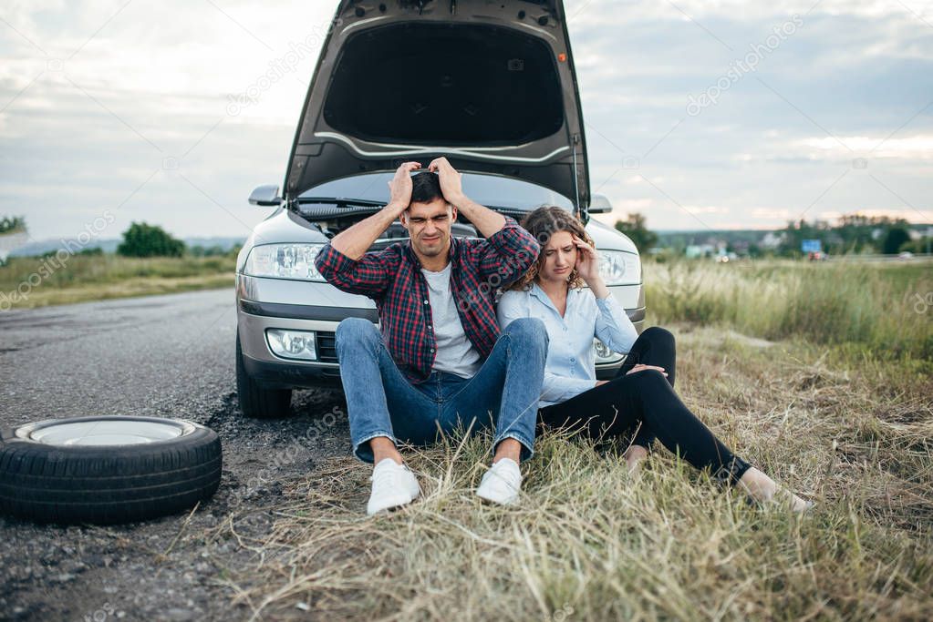  man and woman with broken car