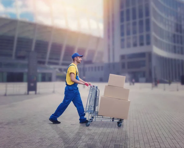 Mannelijke courier met percelen op trolley — Stockfoto