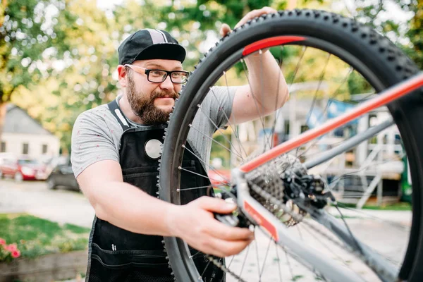 Hombre de servicio que trabaja con rueda de bicicleta — Foto de Stock