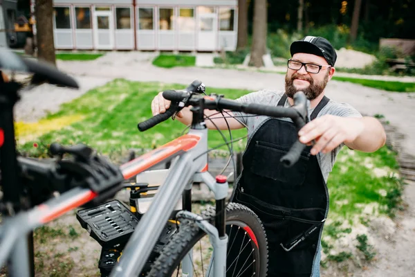 Manliga mekaniker reparerar cykeln — Stockfoto