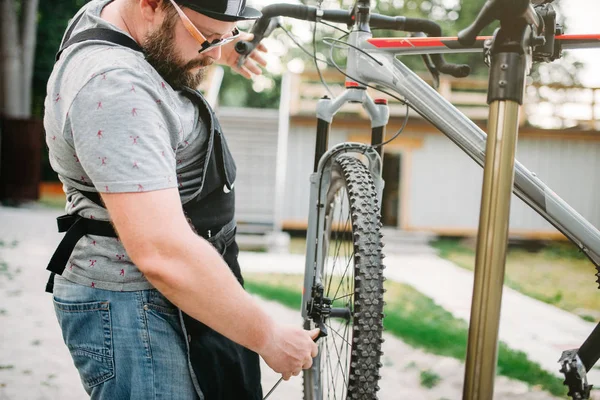 Mâle mécanicien réglage vélo — Photo