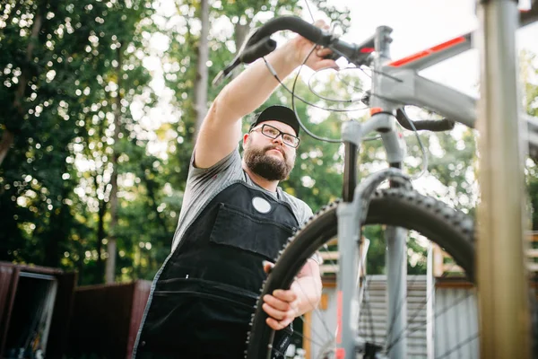 Männlicher Mechaniker stellt Fahrrad ein — Stockfoto