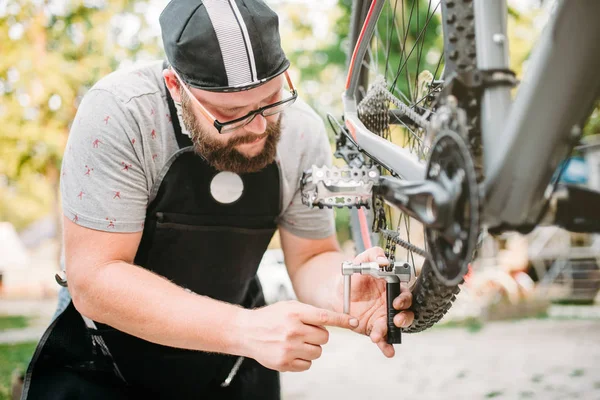 Männlicher Mechaniker repariert Fahrrad — Stockfoto